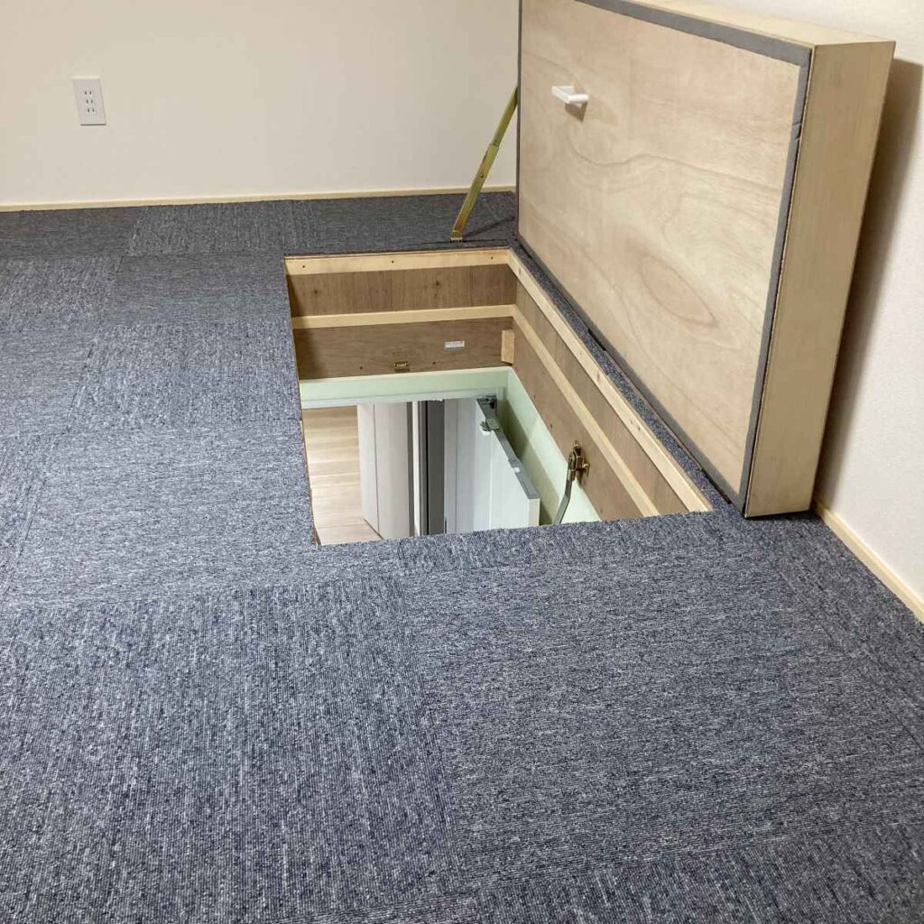 クロス仕上げとタイルカーペットを敷いた小屋裏収納の様子