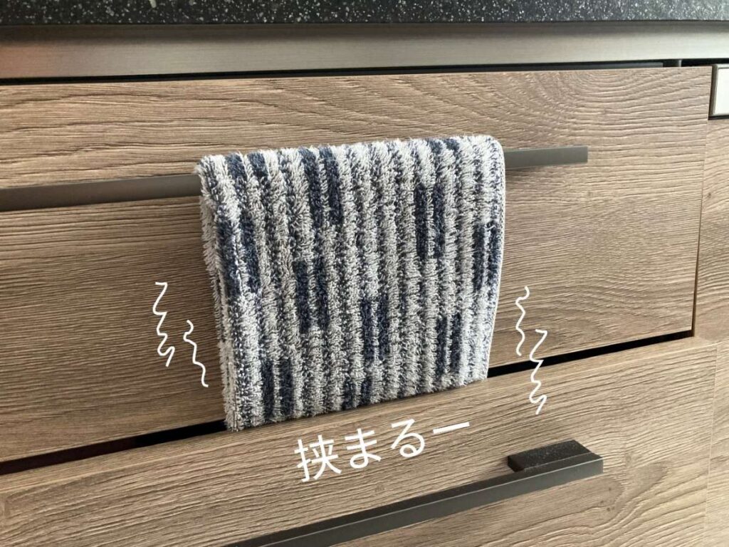 引き出しタイプのグレイスキッチンの取っ手にタオルを掛けると、下の引き出しに挟まれる様子